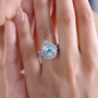 paraiba tourmaline and diamond pear double halo ring in 950 platinum worn on a hand