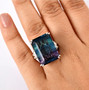rainbow fluorite and moissanite emerald cut cocktail ring in rhodium over sterling silver worn on a hand