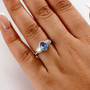 ceylon blue sapphire and diamond ring with padparadscha accents in 10k white gold worn on a hand