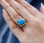 turquoise neon blue apatite and brown zircon halo ring in 18k yellow gold over sterling silver worn on a hand
