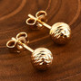 diamond cut ball stud earrings in 10k yellow gold shown in a lifestyle photo