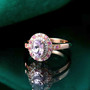 kunzite pink sapphire and moissanite oval double halo ring in 18k rose gold over sterling silver shown in a lifestyle photo