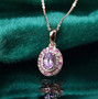 kunzite pink sapphire and moissanite oval double halo pendant necklace in 18k rose gold over sterling silver shown in a lifestyle photo