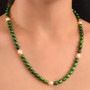 green and white freshwater pearl strand necklace in rhodium over sterling silver worn around the neck
