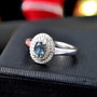 alexandrite and diamond oval double halo ring in 10k white gold shown in a lifestyle photo
