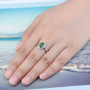 chrome diopside and white zircon oval halo ring in rhodium over sterling silver worn on a hand
