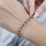 gray spinel oval tennis bracelet in 14k yellow gold worn on a wrist