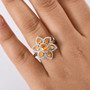 spessartine garnet and zircon flower ring in rhodium over sterling silver worn on a hand