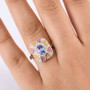 tanzanite and multi color sapphire tri tone ring in rhodium over sterling silver worn on a hand