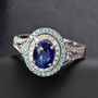 ceylon blue sapphire paraiba tourmaline and diamond oval halo ring in 950 platinum shown in a lifestyle photo