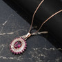 rhodolite garnet and white zircon halo pendant necklace in 18k rose gold over sterling silver shown in a lifestyle photo