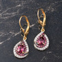 rhodolite garnet and white zircon halo earrings in 18k yellow gold over sterling silver shown in a lifestyle photo