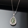 tsavorite garnet and white zircon cluster halo pendant necklace in rhodium over sterling silver shown in a lifestyle photo