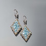 blue apatite cluster earrings in 18k yellow gold and rhodium over sterling silver shown in a lifestyle photo