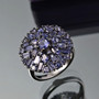 iolite mixed cuts round cluster ring in black and white rhodium over sterling silver shown in a lifestyle photo