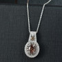 change garnet and white zircon oval double halo pendant necklace in rhodium over sterling silver shown in a lifestyle photo