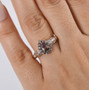 color change garnet and moissanite pear halo ring in 18k rose gold over sterling silver worn on a hand