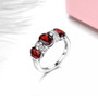 garnet three stone band ring in rhodium over sterling silver shown in a lifestyle photo