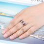 garnet three stone band ring in rhodium over sterling silver worn on a hand