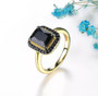 emerald cut black spinel halo ring in 18k yellow gold over sterling silver shown in a lifestyle photo