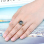 emerald cut black spinel halo ring in 18k yellow gold over sterling silver worn on a hand