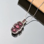 rubellite tourmaline and zircon pendant necklace in rhodium over sterling silver shown in a lifestyle photo