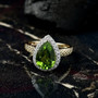 peridot and lab diamond pear halo ring in 10k yellow gold shown in a lifestyle photo