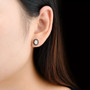 ethiopian opal and garnet halo stud earrings in rhodium over sterling silver worn on the ear