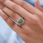 vesuvianite and white zircon heart cluster ring in rhodium over sterling silver worn on a hand