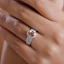 padparadscha sapphire and diamond oval halo ring in 14k white gold worn on a hand