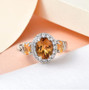 scapolite fire opal and white zircon halo trilogy ring in rhodium over sterling silver shown in a lifestyle photo