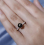 black star sapphire and white zircon solitaire ring in 18k yellow gold over sterling silver worn on a hand