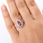 pink apatite pink tourmaline and moissanite pear double halo ring in 18k rose gold over sterling silver worn on a hand