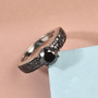 side view of black diamond pave shank solitaire ring in black and white rhodium over sterling silver