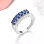 oval sapphire and white zircon band ring in rhodium over sterling silver shown in a lifestyle photo