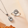 hyalite opal and white zircon ring and pendant jewelry set displayed on soft background