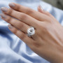 hyalite opal and moissanite oval halo ring in rhodium over sterling silver worn on a hand