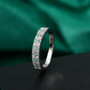 close-up of paraiba tourmaline and diamond platinum band ring on green fabric background