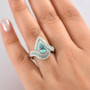 platinum paraiba tourmaline pear halo ring with diamond accents shown on hand