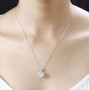 strontium titanate and moissanite pendant necklace in rhodium over sterling silver worn around the neck