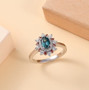 angled view of indicolite tourmaline oval padparadscha and moissanite halo ring in rhodium over sterling
