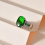 green ammolite ring with chrome diopside and zircon accents displayed on soft neutral background