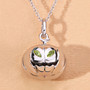 pumpkin pendant with peridot eyes and silver grin photographed on beige background rhodium plated sterling silver necklace