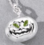 3d pumpkin peridot pendant with eerie green gemstone eyes and carved smile on gray background rhodium plated sterling silver