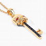 angled view of key pendant with black spinel and ruby eyes in 18k yellow gold over sterling silver