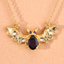 full view of bat necklace with garnet and black spinel in 18k yellow gold over sterling silver
