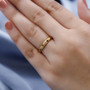 lifestyle image of orange diamond flush set band ring worn on hand, displaying a refined minimalist style with subtle diamond sparkle and radiant gold tone