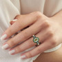 demantoid tsavorite oval garnet and moissanite double halo ring in 18k yellow gold over sterling silver worn on a hand