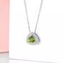 peridot and white zircon trillion halo necklace in rhodium over sterling silver shown in a lifestyle photo