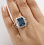london blue emerald cut topaz and white zircon baguette halo ring in rhodium over 925 silver worn on a hand